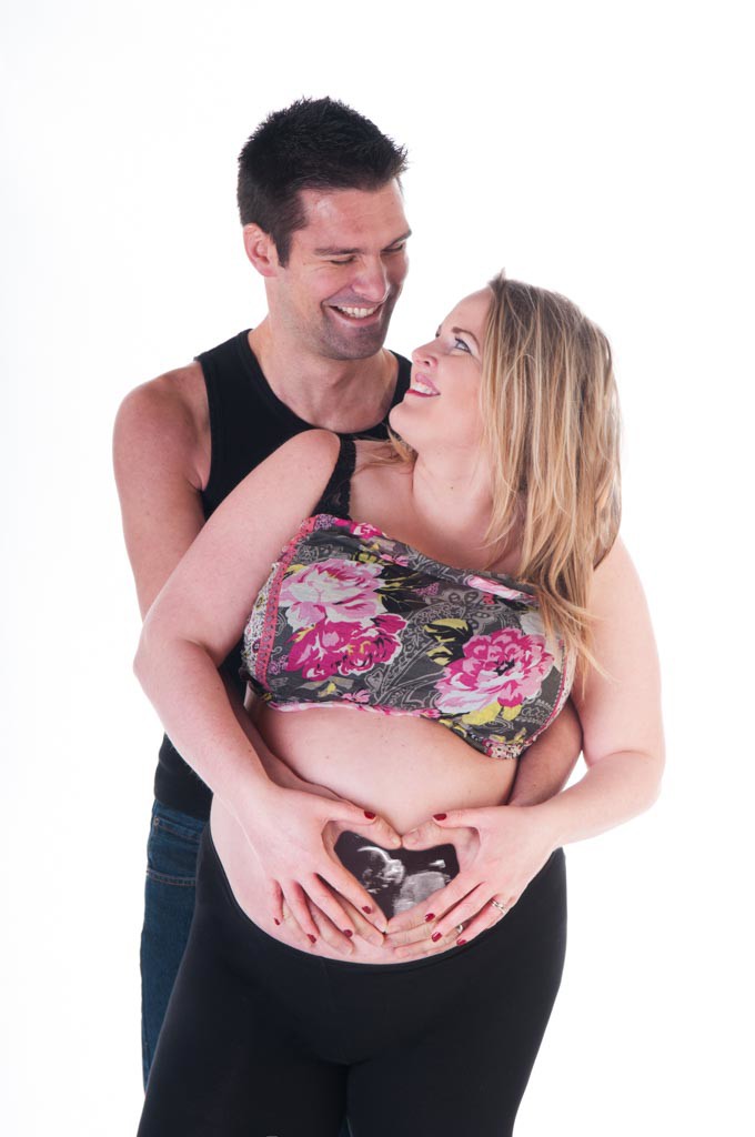 Baby scan photo inserted into hands on bump