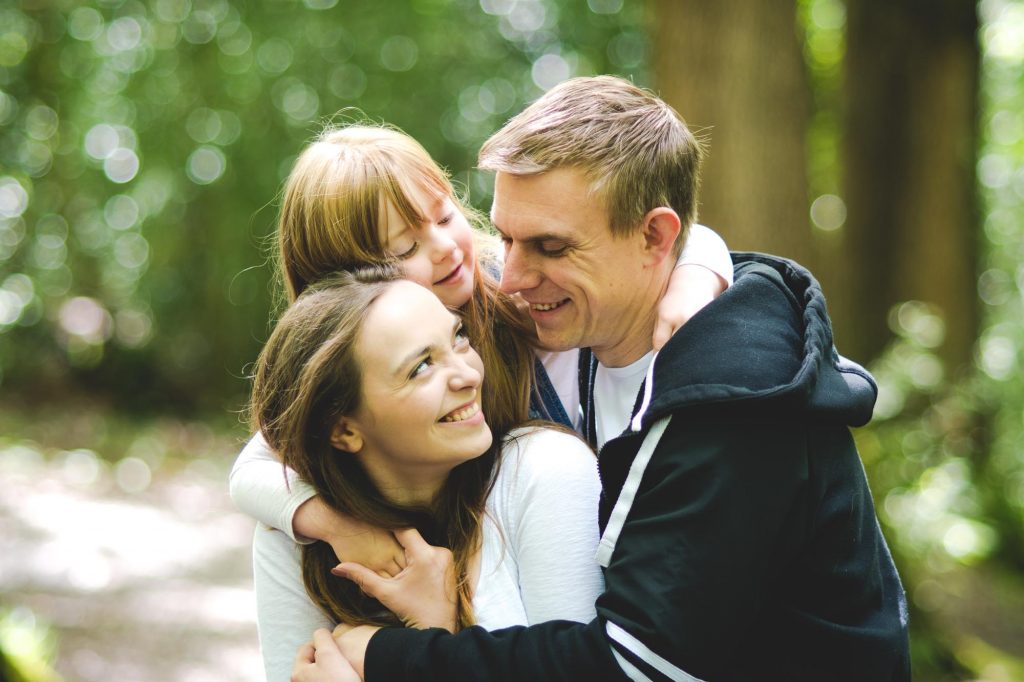 Small family photo of a mum, dad and daughter
