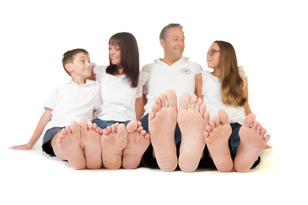 A family photo of a family of four, focused on the subjects feet