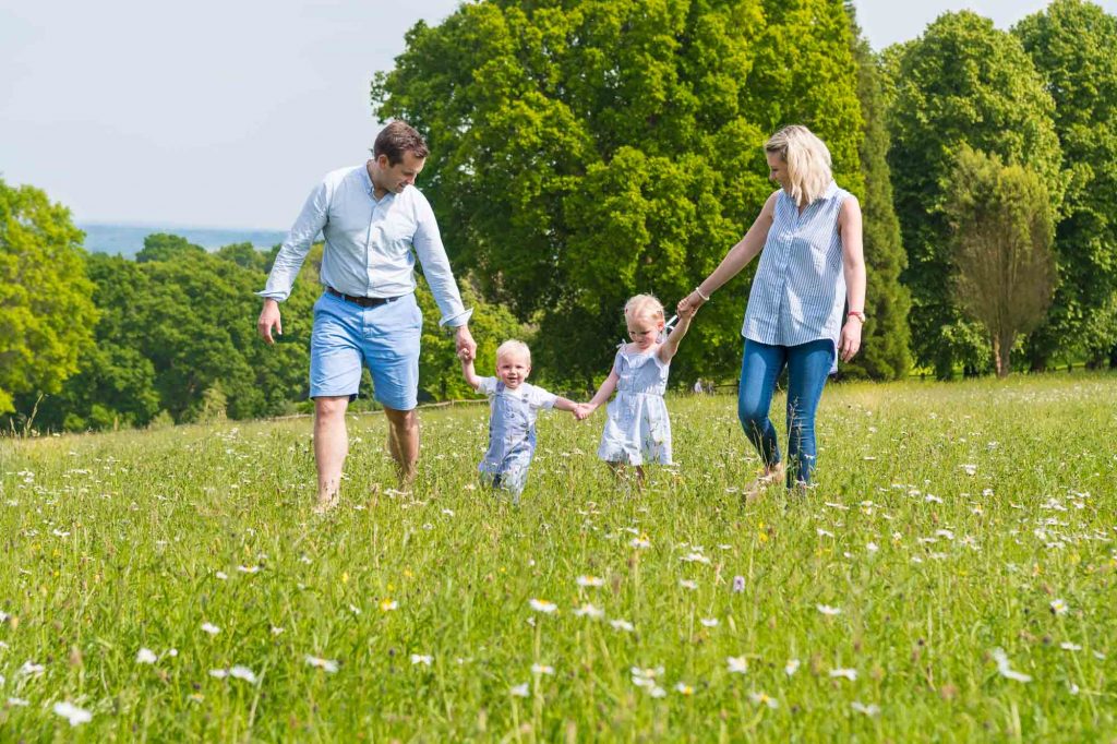Location family portrait of a young family walking in a field of flowers