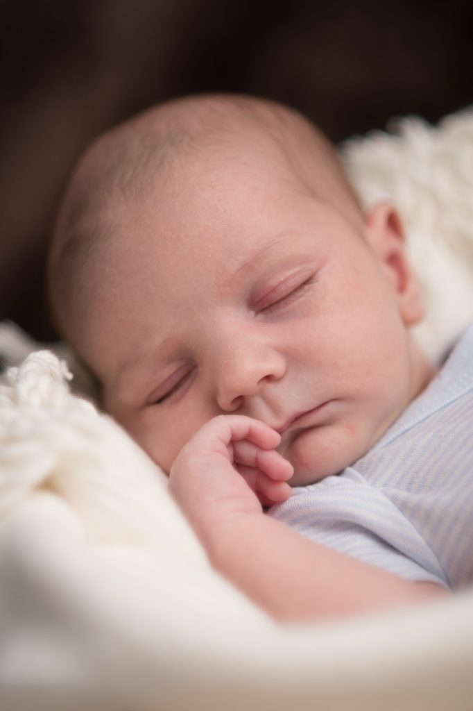 A close up of a baby asleep in a basket