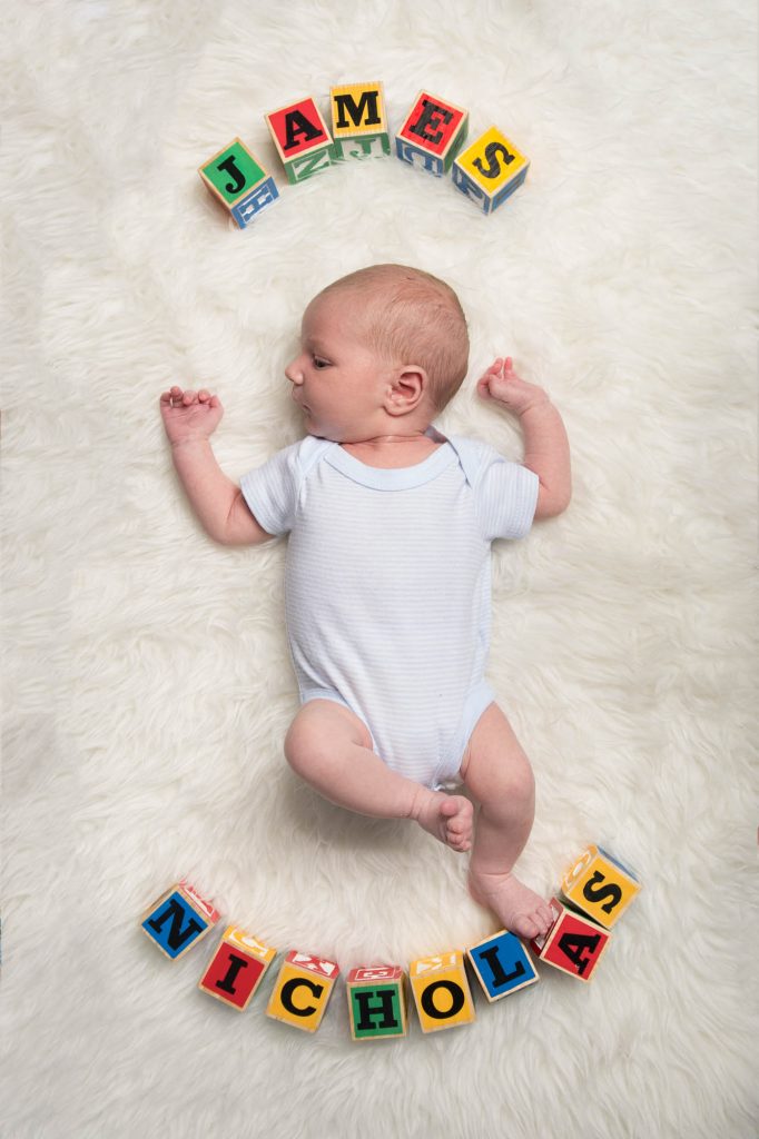A baby with the name James Nicholas shown in alphabet blocks