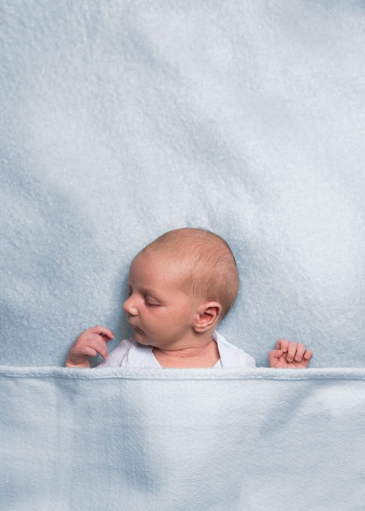 A baby asleep under a blanket