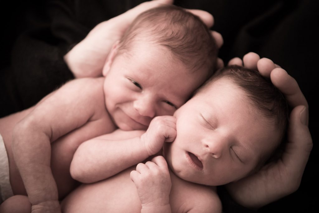Photograph of twin babies in their father's hands
