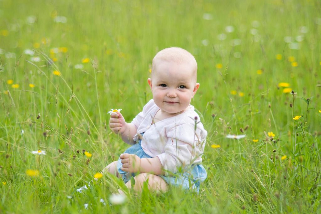 Baby sitting in a field of wild flowers