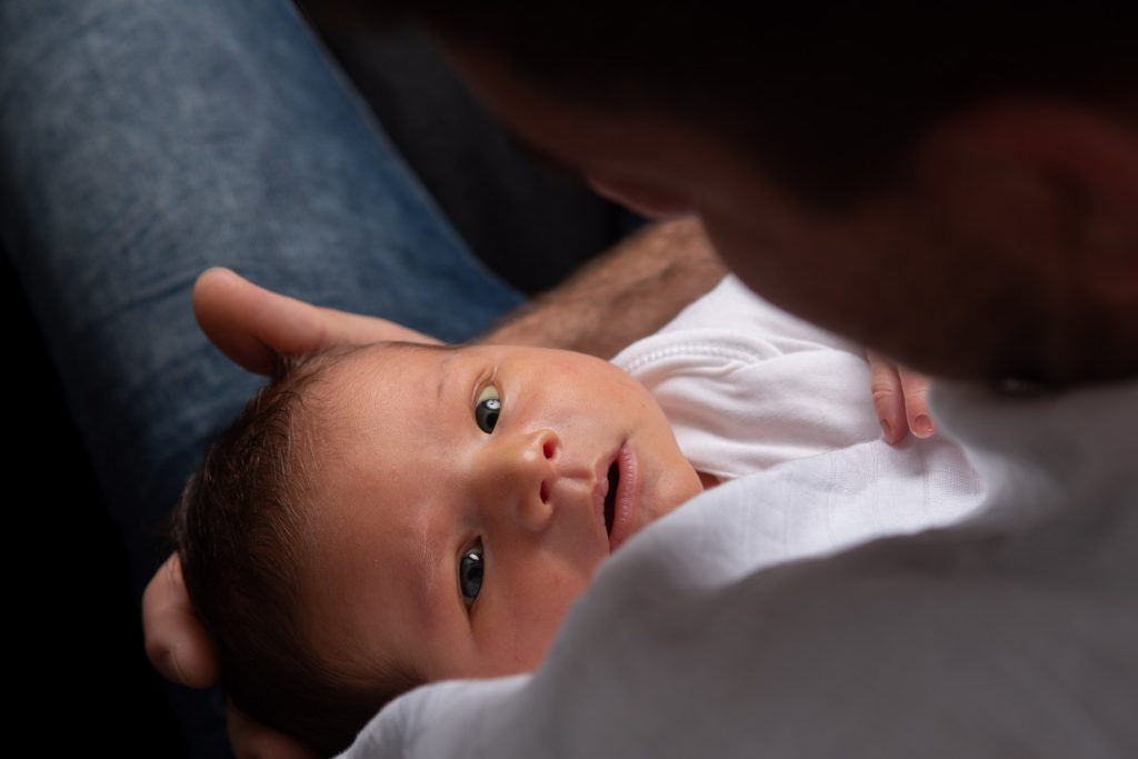 newborn baby staring up at his father