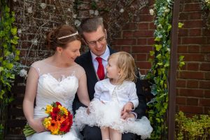 wedding photo of bride and groom talking with their daughter