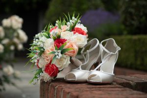wedding photo showing the detail of the bride's shoes and bouquet