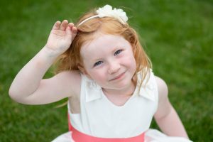 wedding photo of a flower girl looking at the photographer