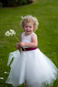 wedding photo of a flower girl holding a flower
