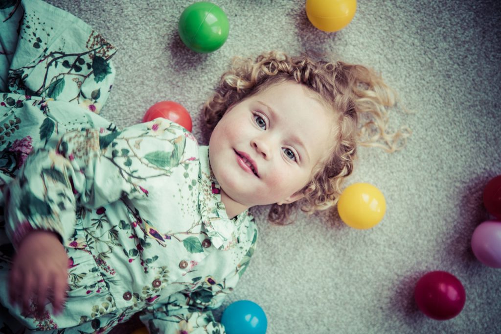 Young girl playing with colourful balls