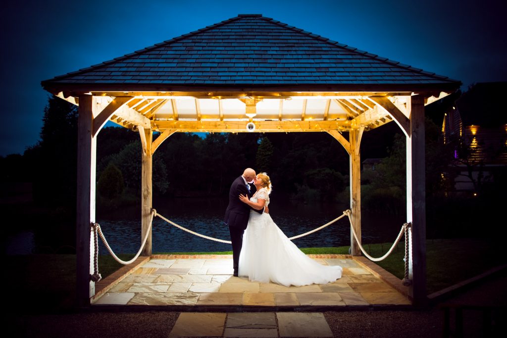 A couple kissing under the gazebo at Brooklands Barn