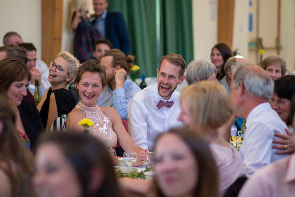 Bride and groom laughing during the speeches