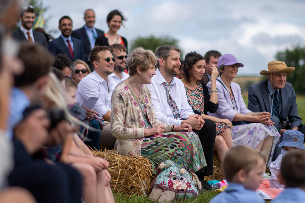 Wedding guests sitting on hay bales