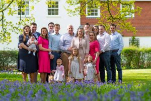 Extended family photographed on the edges of a bluebell wood.