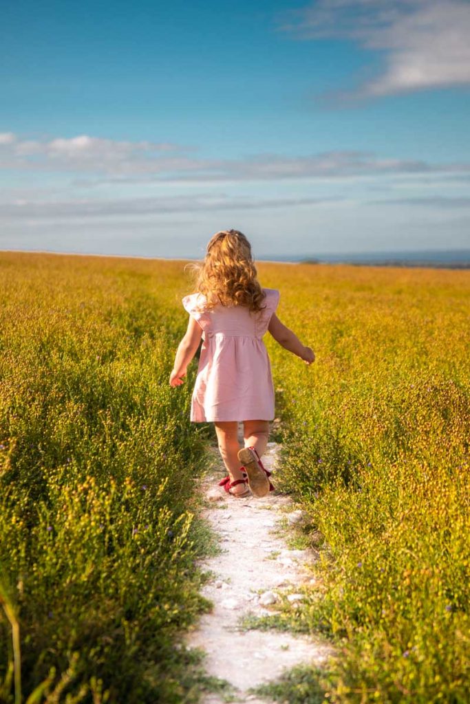 Young girl running along the South Downs Way