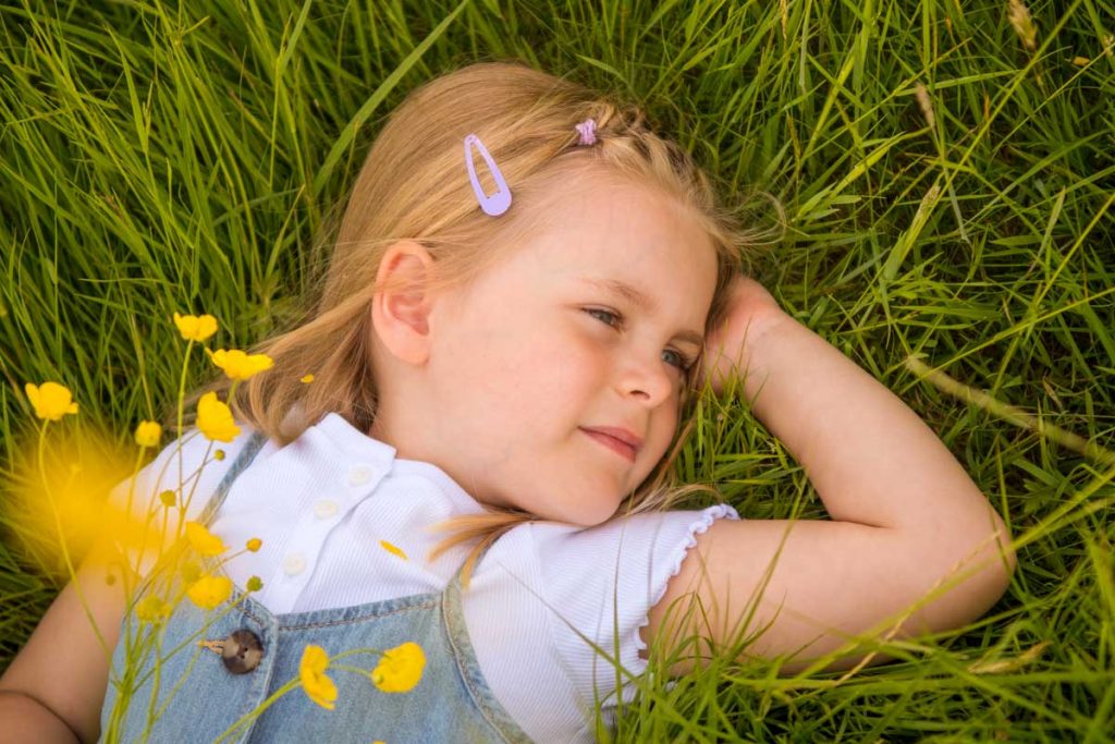Young girl lying amongst wildflowers