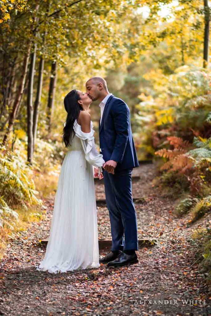 couple kissing whilst holding hands after getting engaged