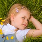 A young girl relaxes in a wildflower meadow