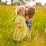 Two children playing in a wildflower meadow