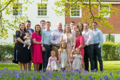 A family photographed on the edge of a bluebell wood