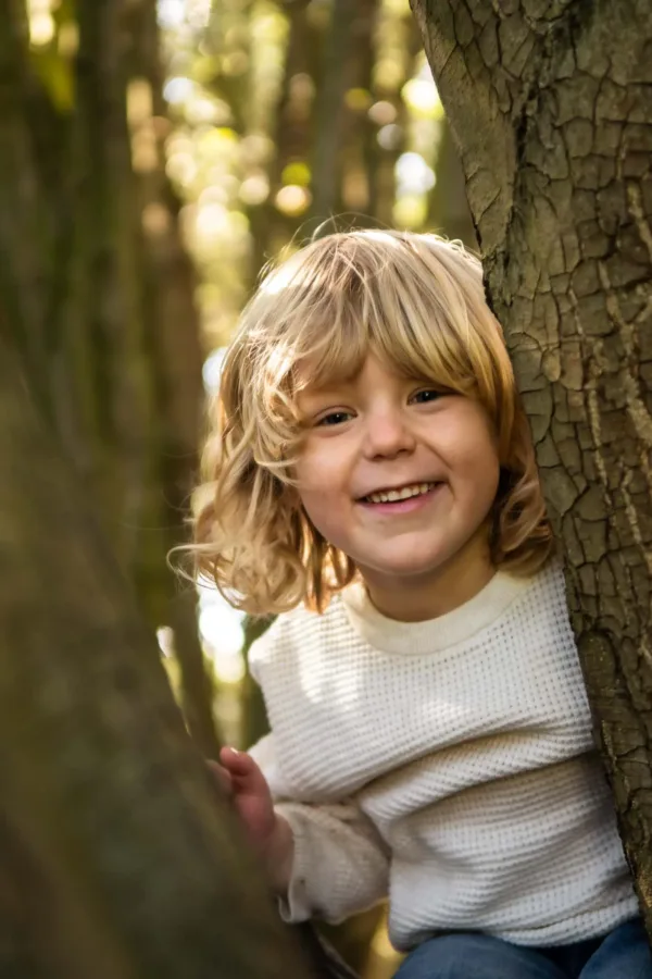 A portrait of a young boy playing in a tree