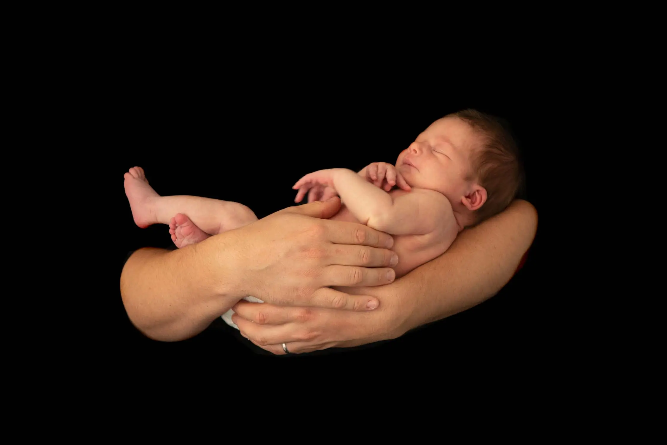 Newborn in their father's arms