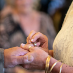 Wedding ring going onto groom's finger at western themed wedding