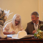 Signing of the register at western themed wedding in Horsham registry office West Sussex