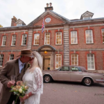 Bride and groom kissing in front of Horsham Registry Office western themed wedding