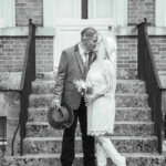 newlywed couple kissing at the base of a flight of stairs - western themed wedding at Horsham Registry Office